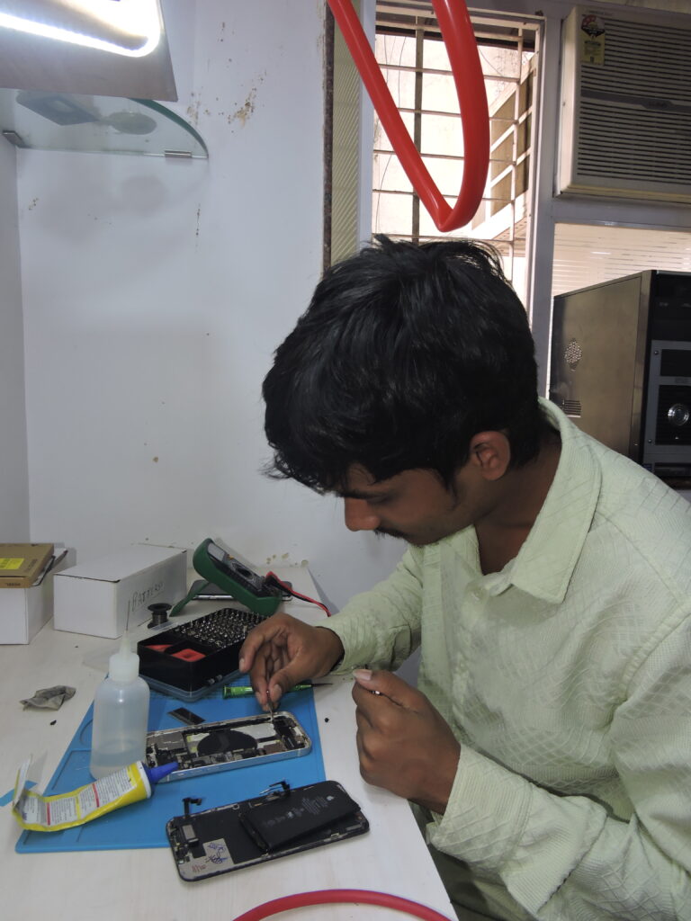 Trained student confidently repairing his own mobile phone.