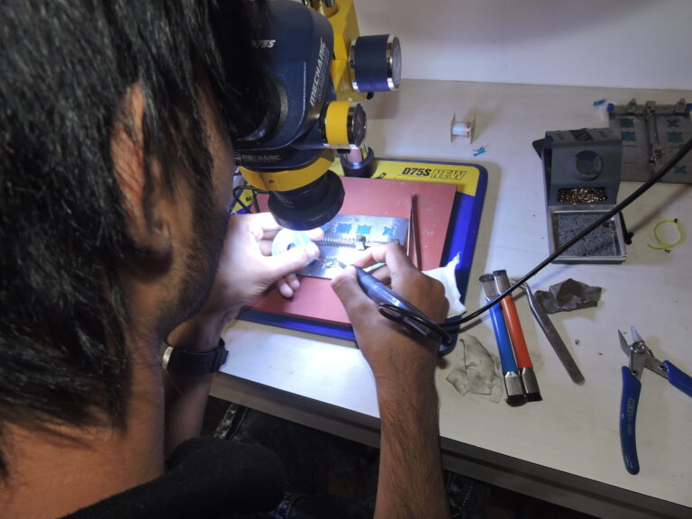 Students learning IC handling and repair through hands-on practice.
