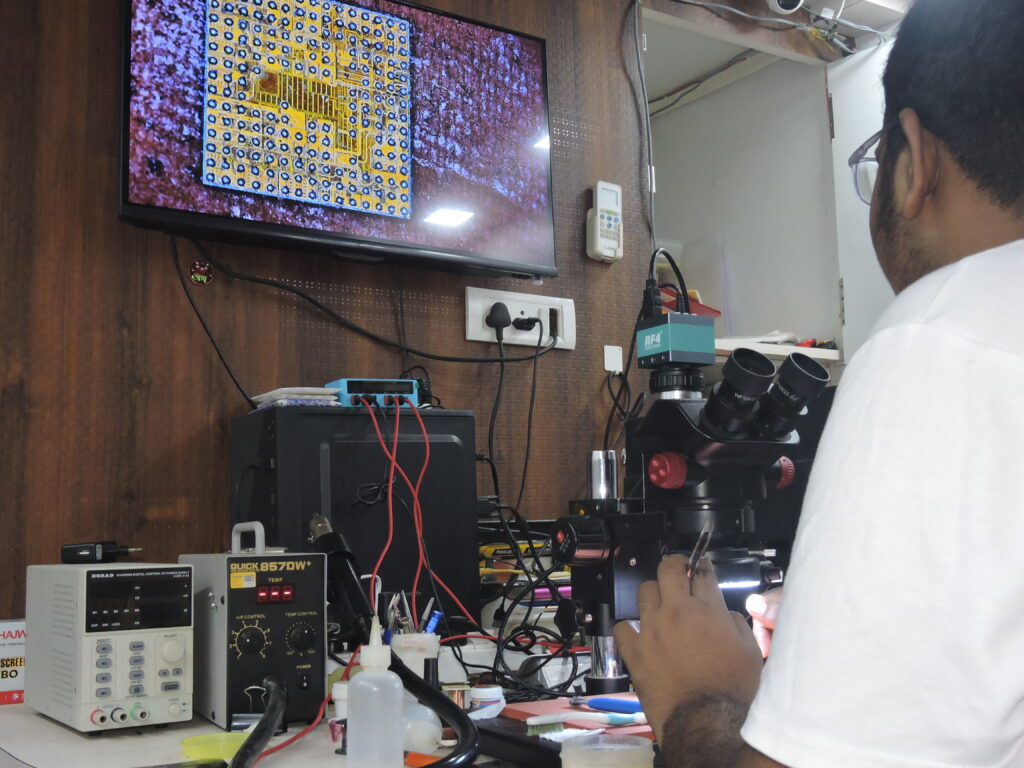 Student learning iPhone IC reballing in a practical training session.