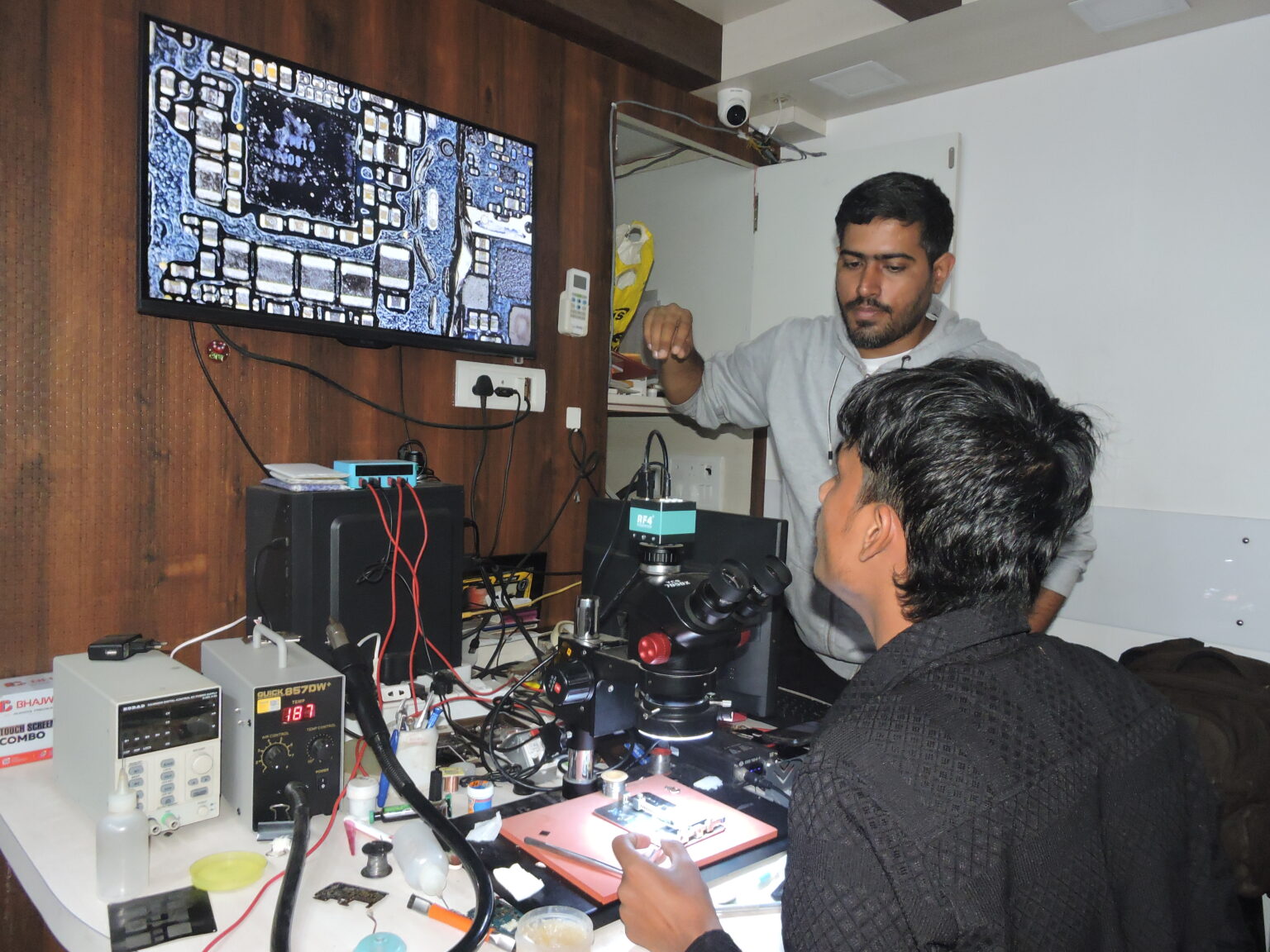 Trainer providing personal attention while teaching how to change an integrated circuit (IC).
