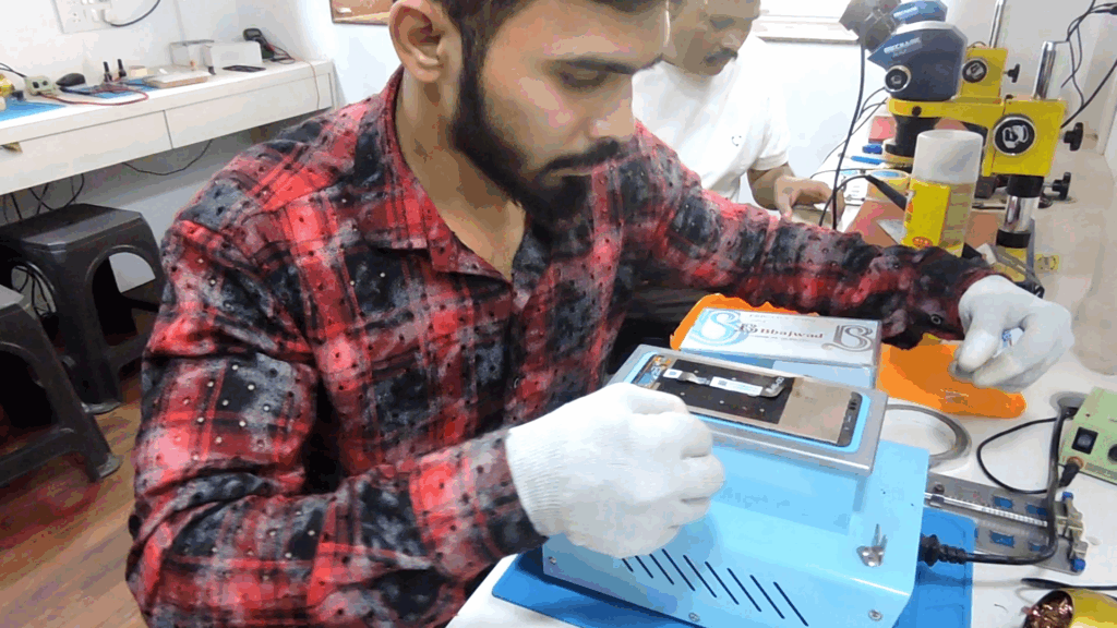 Student performing display cutting practice on a mobile phone screen.